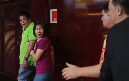 An upset relative of a passenger of the missing Malaysia Airlines flight MH370 is led away after approaching officials for information at a hotel in Putrajaya March 9, 2014. REUTERS/Samsul Said