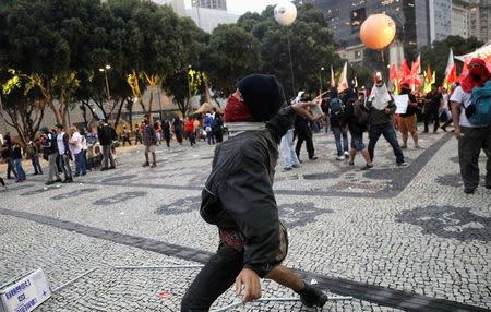 A demonstrator throws a stone during clashes with riot police in a protest against President Michel Temer's proposal reform of Brazil's social security system during general strike in Rio de Janeiro, Brazil, April 28, 2017. REUTERS/Ricardo Moraes