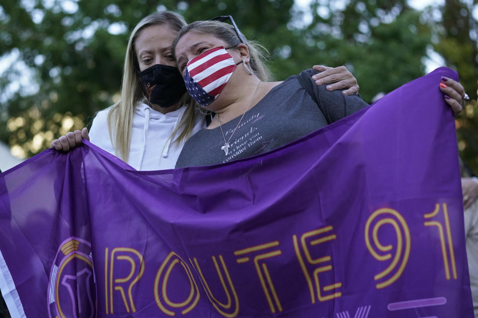 Sarah Lamers, left, comforts Jill Winters during a ceremony Thursday, Oct. 1, 2020, on the anniversary of the mass shooting three years earlier in Las Vegas. The ceremony was held for survivors and victim's families of the deadliest mass shooting in modern U.S. history. (AP Photo/John Locher)