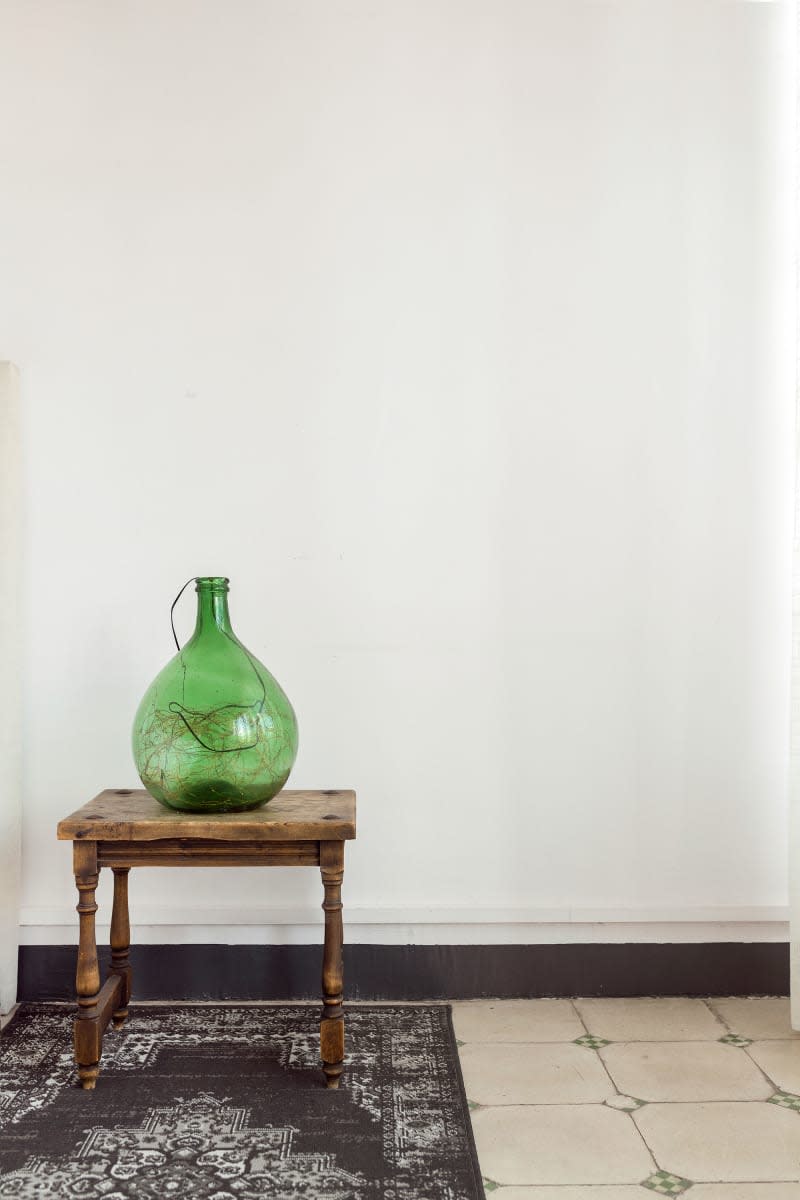 Green glass vessel accents light bedroom.