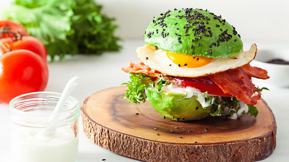 Lazy keto breakfast with eggs and bacon sandwiched inside an avocado