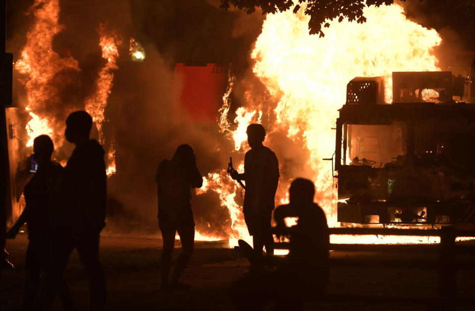 Garbage and dump trucks were set ablaze on Sunday, Aug. 23, 2020 by rioters near the Kenosha County Courthouse where they had been set up to prevent damage to the building. The building was still damaged and was closed on Monday. (Sean Krajacic/Kenosha News via AP)