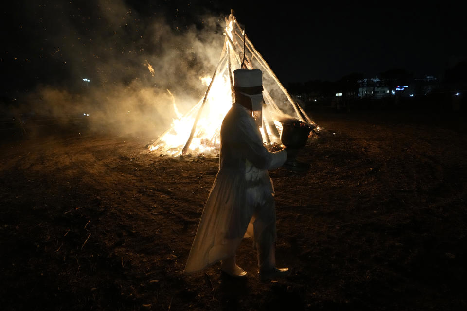 An Iranian Zoroastrian priest walks near a giant bonfire in a ceremony celebrating Zoroastrians ancient mid-winter Sadeh festival the outskirts of Tehran, Iran, Tuesday, Jan. 30, 2024. Hundreds of Zoroastrian minorities gathered after sunset to mark their ancient feast, creation of fire, dating back to Iran's pre-Islamic past. (AP Photo/Vahid Salemi)