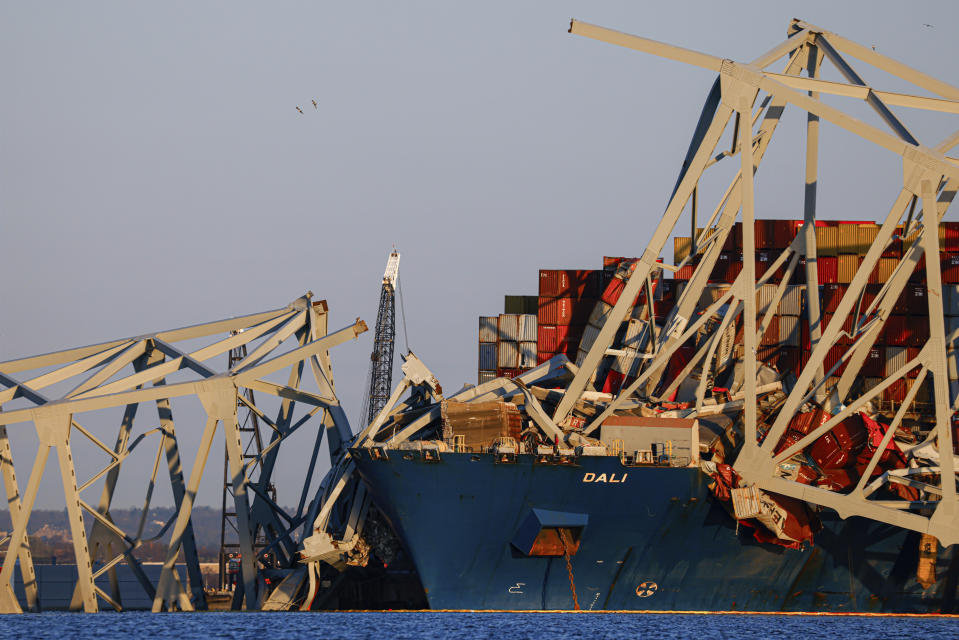 Cranes stand by as the wreckage of the Francis Scott Key Bridge rests on the container ship Dali, Saturday, March 30, 2024, in Baltimore. (AP Photo/Julia Nikhinson)