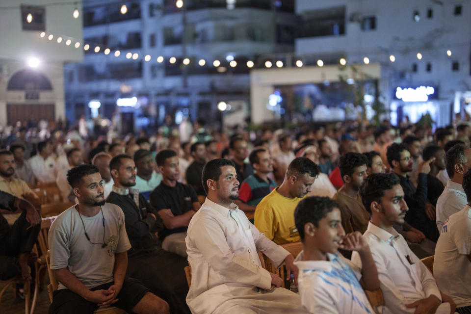 People gather as they watch soccer on a giant screen in Jeddah, Saudi Arabia, Wednesday, Dec 20, 2023. (AP Photo/Manu Fernandez)
