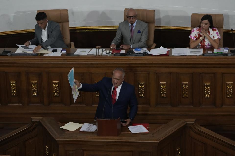 Venezuelan lawmaker Diosdado Cabello holds the new map of Venezuela with the Essequibo territory, a large swath of land that is administered and controlled by Guyana but claimed by Venezuela, during a session at the National Assembly in Caracas, Venezuela, Wednesday, Dec. 6, 2023. (AP Photo/Ariana Cubillos)