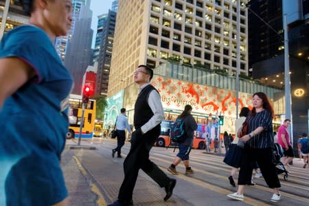 People cross a street the Central business district in Hong Kong