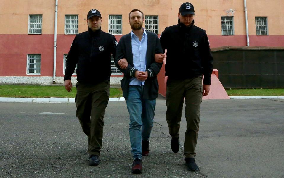 Jack Shepherd, a British man wanted for the manslaughter of a woman killed during a date on a speedboat in London, walks escorted by police in Tbilisi, Georgia