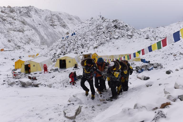 An injured person is carried to a rescue helicopter at Everest Base Camp on April 26, 2015