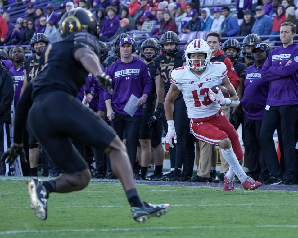 Wisconsin Badgers wide receiver Chimere Dike (13) runs the ball as Northwestern Wildcats defensive back Cameron Mitchell (2) seen running towards him during the second half of their game Saturday, Oct. 8, 2022, at Ryan Field in Evanston, IL. The Badgers defeated the Wildcats 42-7.