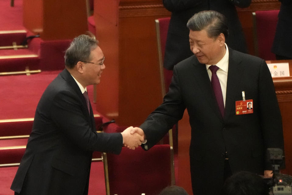 Chinese President Xi Jinping at right is congratulated by Li Qiang after he is unanimously elected as President during a session of China's National People's Congress (NPC) at the Great Hall of the People in Beijing, Friday, March 10, 2023. Chinese leader Xi Jinping was awarded a third five-year term as president on Friday, putting him on track to stay in power for life. (AP Photo/Mark Schiefelbein)