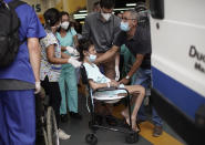 A patient is evacuated from the Bonsucesso Federal Hospital, which has a COVID-19 unit, while firefighters douse a fire in Rio de Janeiro, Brazil, Tuesday, Oct. 27, 2020. According to the fire department, there were no casualties. (AP Photo/Silvia Izquierdo)