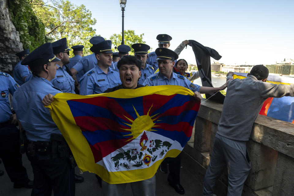 A Tibetan protester shouts surrounded by Hungarian police next to a Tibetan flag in Gellert Hill, against Chinese President Xi Jinping's visit to Budapest, Hungary on Thursday, May 9, 2024. (AP Photo/Denes Erdos)