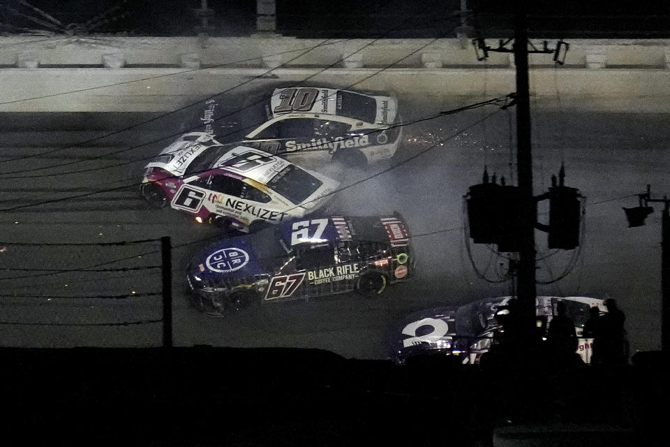 Travis Pastrana (67), Brad Keselowski (6) and Aric Almirola (10) crash during the NASCAR Daytona 500 auto race Sunday, Feb. 19, 2023, at Daytona International Speedway in Daytona Beach, Fla. (AP Photo/Chris O'Meara)