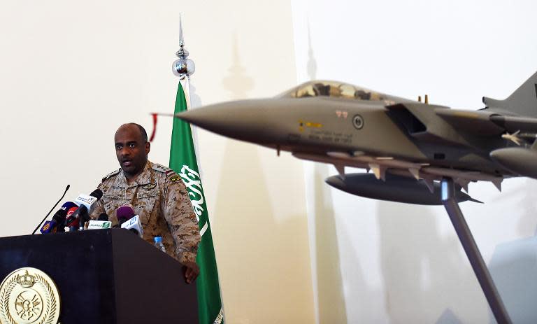 Saudi Brigadier General Ahmed Asiri, spokesman of the Saudi-led coalition forces, speaks to the media next to a replica of a Tornado fighter jet, at the Riyadh airbase in the Saudi capital on March 26, 2014