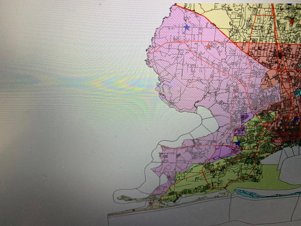 A image from the leaked files of Commissioner Jeff Bergosh's iPhone shows a picture of a computer monitor displaying a redistricting plan moving Perdido Key into District 1. The image has a timestamp that matches a text file when Bergosh sent an image to David Bear.