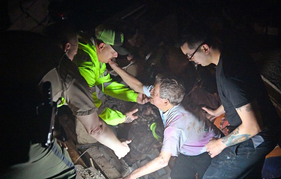 Off-duty Metro Nashville Police Officer Tyler Manivong, right, helps Bill Wallace out from the basement of his Barrett Drive home, which collapsed on him and his wife, Shirley, trapping them under rubble. Officer Paul Foutch, left, reaches for Wallace in Mt. Juliet on Tuesday, March 3, 2020.