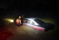 <p>Rescue staff investigate an empty flooded vehicle in Fajardo, Puerto Rico. (AP) </p>
