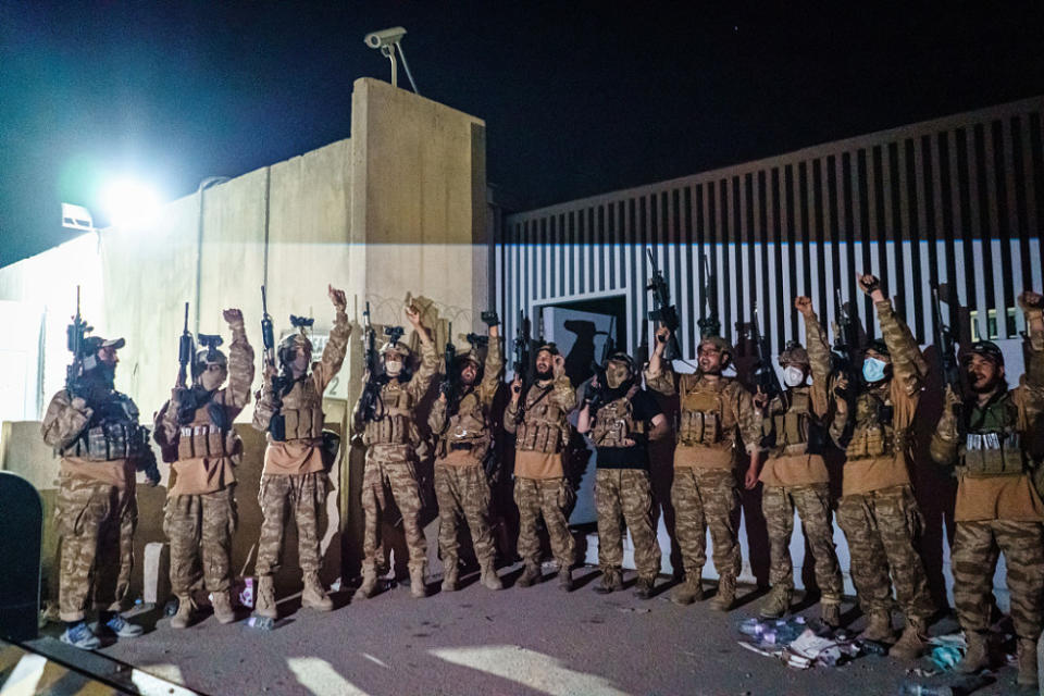 穿著美軍裝備的塔利班部隊在喀布爾機場門口鳴槍慶祝美軍離開，並高呼口號。   圖 : 翻攝視覺中國