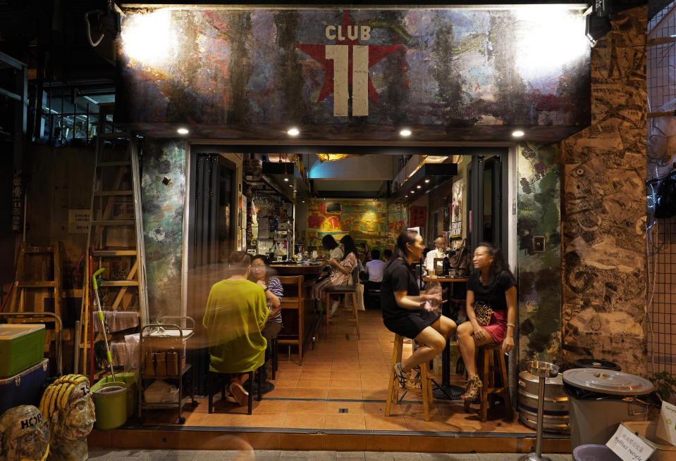 In this Oct. 7, 2020, photo, customers sit at Club 71 in Hong Kong. The bar known as a gathering place for pro-democracy activists and intellectuals is closing. (AP Photo/Vincent Yu)