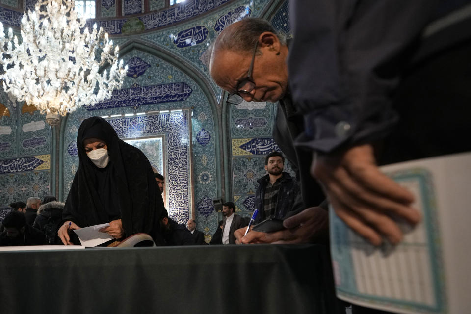 Voters fill out their ballots in the parliamentary and Assembly of Experts elections at a polling station in Tehran, Iran, Friday, March 1, 2024. Iran began voting Friday in its first elections since the mass 2022 protests over its mandatory hijab laws after the death of Mahsa Amini, with questions looming over just how many people will turn out for the poll. (AP Photo/Vahid Salemi)