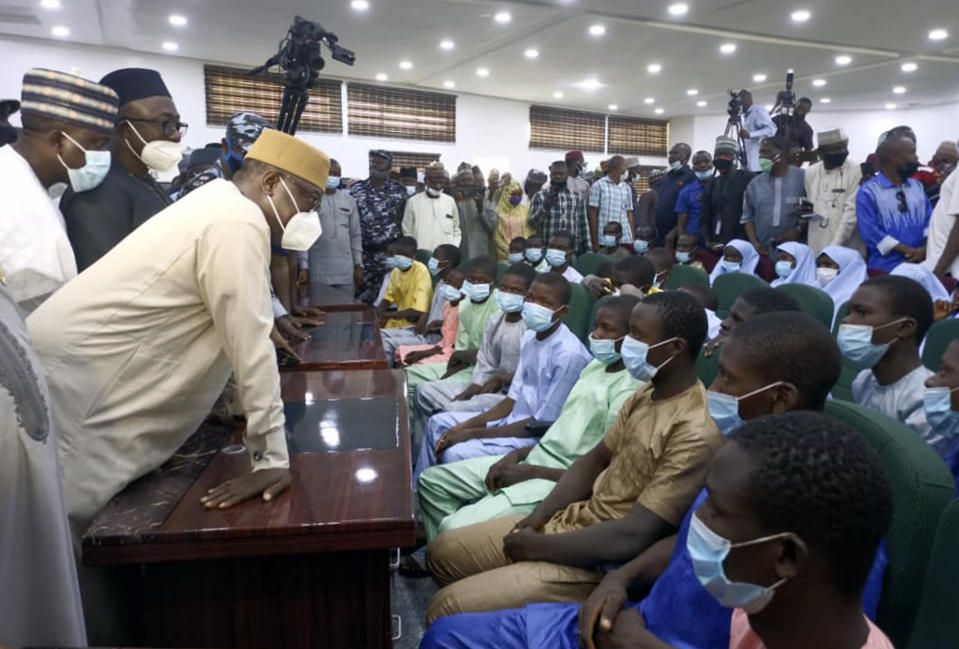 Students and teachers who were abducted by gunmen from the Government Science College Kagara two weeks ago are seen after their release meeting with the state Governor Abubakar Sani Bello, left, in Minna, the capital of Niger state, in Nigeria Saturday, Feb. 27, 2021. Their release was announced a day after police said gunmen had abducted more than 300 girls Friday from a boarding school elsewhere in northern Nigeria, in Zamfara state. (AP Photo)