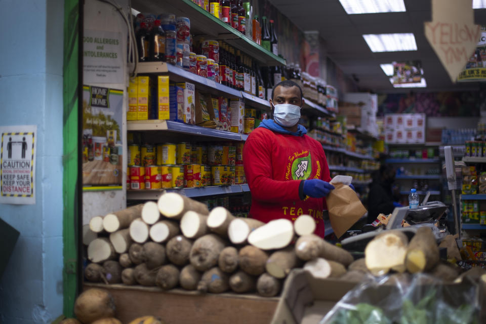 A stall holder in a protective face mask in Brixton Market in South London, as the UK continues in lockdown to help curb the spread of the coronavirus.