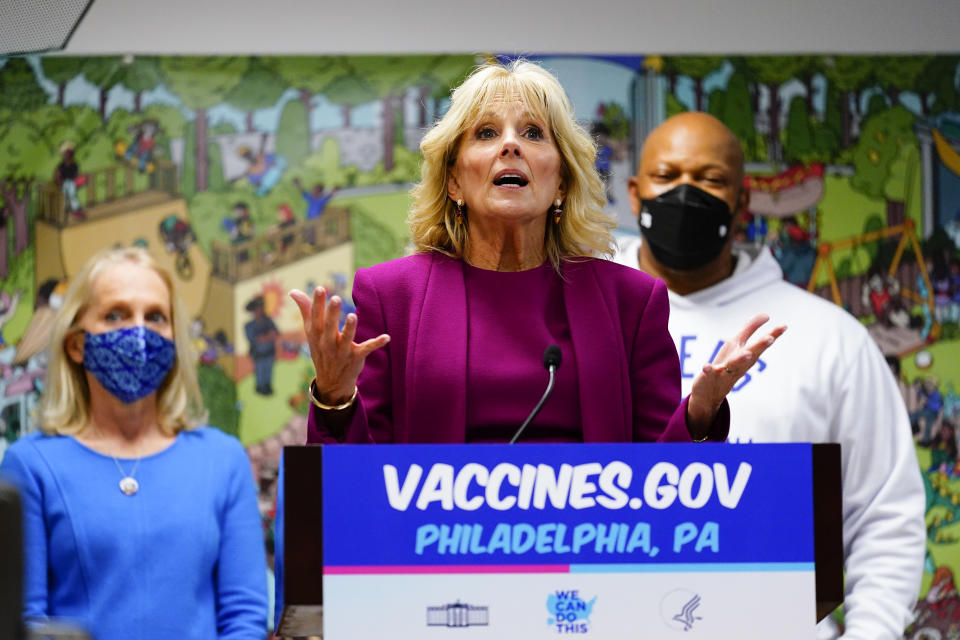 FILE - First lady Jill Biden, center, accompanied by Rep. Mary Gay Scanlon, D-Pa., left, and former NBA Philadelphia 76ers player World B. Free, speaks after visiting a pediatric COVID-19 vaccination clinic at the Children's Hospital of Philadelphia's Nicholas and Athena Karabots Pediatric Care Center in Philadelphia, on Dec. 3, 2021. (AP Photo/Matt Rourke, File)