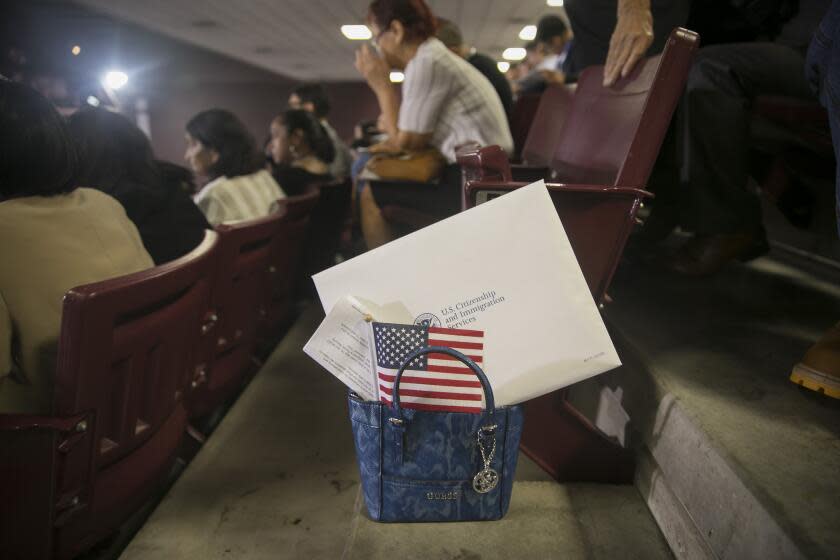 Paperwork and a small American flag are tucked into a purse before the beginning of a naturalization ceremony at the M.O. Campbell Education Center on Saturday, Sept. 18, 2019, in north Houston. Over 2200 immigrants took oaths to become naturalized citizens.