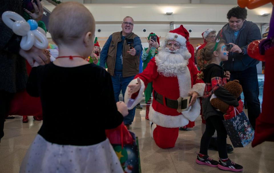 Santa Claus, portrayed by Bill Neelsen, welcomes dozens of children outside the gate during the Flight to the North Pole event at the Detroit Metropolitan Airport on Tuesday, Dec. 12, 2023.