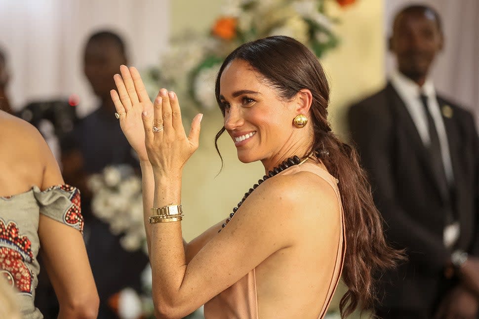Meghan Markle claps as she arrives with Prince Harry during their visit at the Lightway Academy in Abuja on May 10, 2024 as they visit Nigeria as part of celebrations of Invictus Games anniversary. 