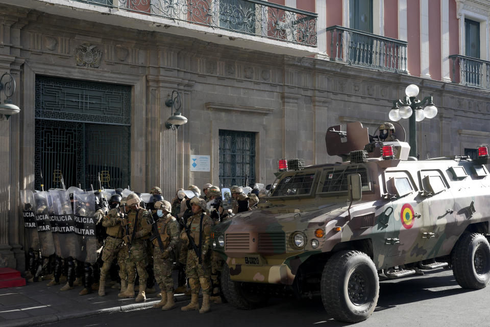 An armored vehicle and military police form outside the government palace at Plaza Murillo in La Paz, Bolivia, Wednesday, June 26, 2024. Armored vehicles rammed into the doors of Bolivia's government palace Wednesday as President Luis Arce said the country faced an attempted coup. (AP Photo/Juan Karita)