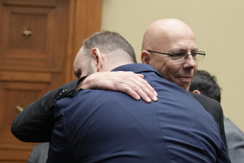 Matthew Haynes, right, a founding owner of the club, hugs James Slaugh, a survivor of Club Q shooting, after a House Oversight Committee hearing, Wednesday, Dec. 14, 2022, on Capitol Hill in Washington. (AP Photo/Mariam Zuhaib)