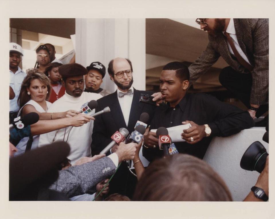 Luther Campbell, right, leader of rap group 2 Live Crew, and lawyer Bruce Rogow, center, speak to reporters outside the courthouse.