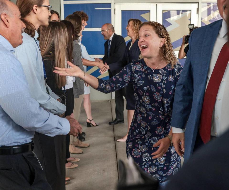 El secretario de Educación de Estados Unidos, Miguel Cardona, a la derecha, y la representante federal Debbie Wasserman Schultz son recibidos por estudiantes y miembros del personal, el lunes 4 de abril de 2022, mientras visitan la secundaria Cypress Bay en Weston, Florida, donde se informaron más sobre los programas de desarrollo profesional de la escuela, incluyendo la FBI Cyber Stem Academy.