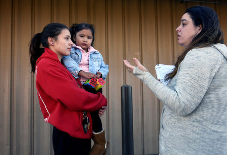 Brenna Eagle Shield and her daughter Kason Jeunesse listen to canvass worker Allyssa Castle explain the voting process for the 2018 mid-term elections on the Standing Rock Reservation near Fort Yates, North Dakota, U.S. October 26, 2018. REUTERS/Dan Koeck