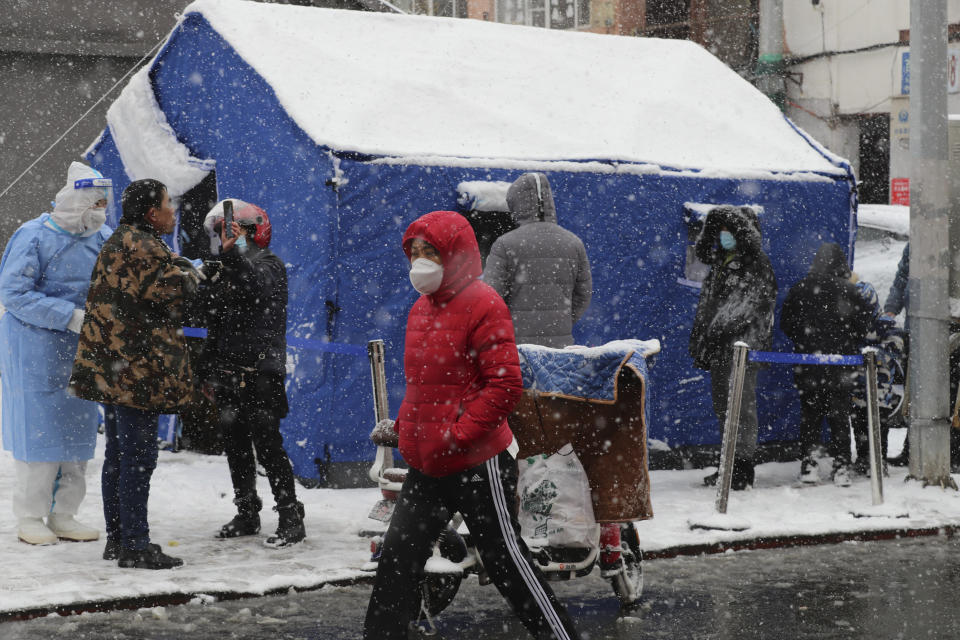 Residents take their COVID-19 test at a tent as it snows in Changchun city in northeastern China's Jilin province Tuesday, March 15, 2022. China's new COVID-19 cases Tuesday more than doubled from the previous day as the country faces by far its biggest outbreak since the early days of the pandemic. (Chinatopix Via AP) CHINA OUT