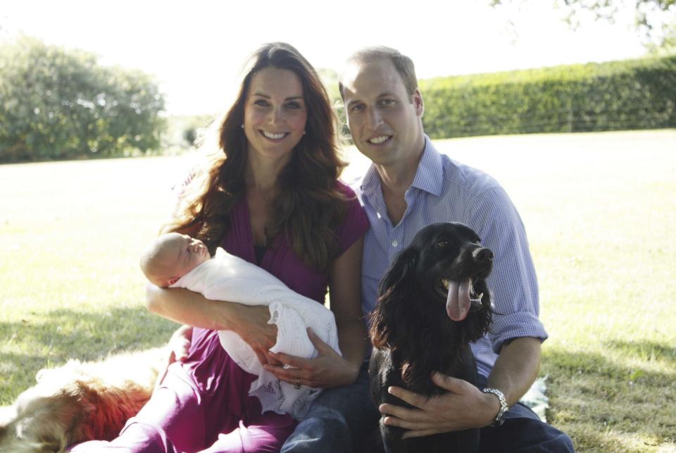 The Duke and Duchess of Cambridge pose in the garden of the Middleton family home in Bucklebury, England with their son Prince George, cocker spaniel Lupo and Middleton family pet Tilly, in this undated photograph released Aug. 19, 2013.