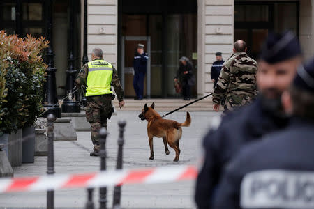 French gendarmes with a detection dog and police stand in front of the French financial prosecutor's offices following a bomb alert in central Paris, France, March 20, 2017. REUTERS/Benoit Tessier