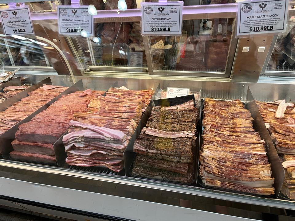 Rows of different types of bacon in a glass case