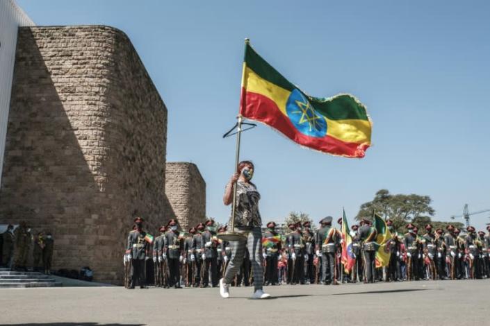 A woman carries an Ethiopian national flag in ceremonies at the prime minister's compound in Addis on Wednesday to honour the armed forces