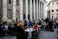 People eat in a restaurant in central Rome, Sunday, Oct. 25, 2020. For at least the next month, people outdoors except for small children must now wear masks in all of Italy, gyms, cinemas and movie theaters will be closed, ski slopes are off-limits to all but competitive skiers and cafes and restaurants must shut down in early evenings, under a decree signed on Sunday by Italian Premier Giuseppe Conte, who ruled against another severe lockdown despite a current surge in COVID-19 infections. (Cecilia FabianoLaPresse via AP)
