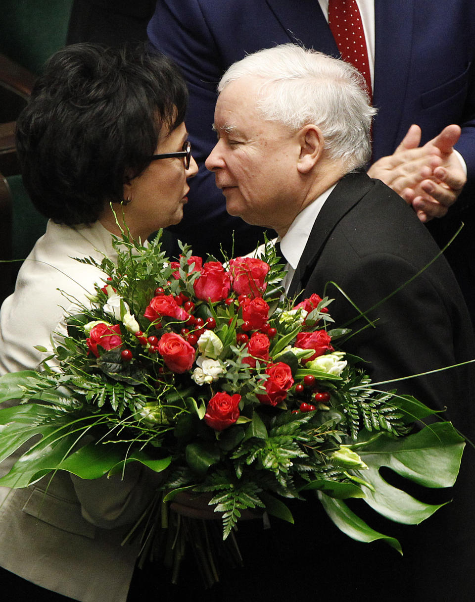 Leader of Poland's ruling right-wing party, Jaroslaw Kaczynski, right, offers flowers to his party member Elzbieta Witek, after she was chosen AS the speaker of the new lower house of parliament after elections, at its inaugural session in Warsaw, Poland, Tuesday, Nov. 12, 2019.(AP Photo/Czarek Sokolowski)