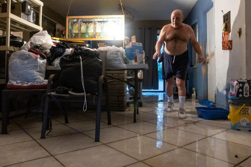 Sam Demarco makes his way through his wet living room after a heavy downpour flooded his home on Wednesday, June 12, 2024, in Hollywood, Fla. (Matias J. Ocner/Miami Herald via AP)