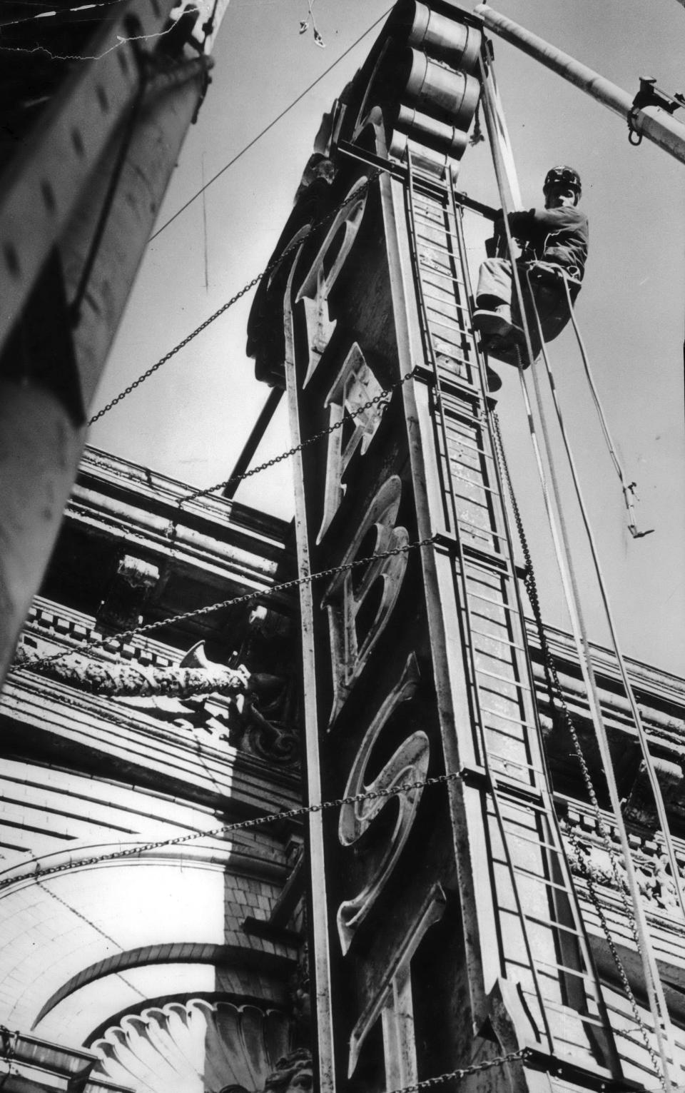 A worker loosened support chains to remove the Pabst Theater Sign in 1974. The sign was taken down as part of the landmark theater's refurbishing.