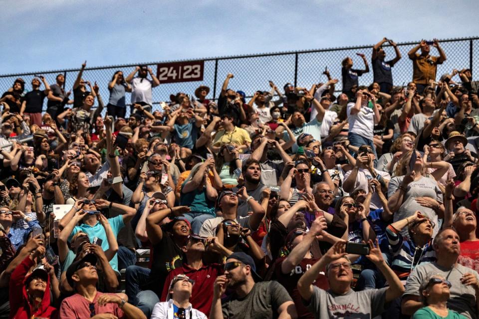 People look at the sky at Saluki Stadium, as the moon is about to block the sun in a total solar eclipse, in Carbondale, Illinois.<span class="copyright">Evelyn Hockstein—Reuters</span>