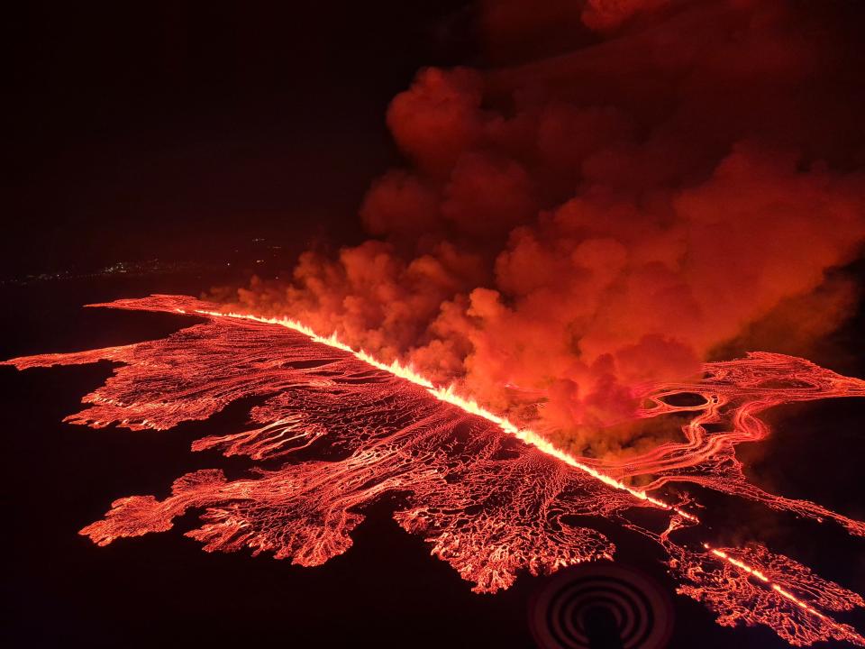 This handout picture released by the Icelandic Coast Guard on March 16, 2024 shows billowing smoke and flowing lava pouring out of a new fissure, during a surveilance flight above a new volcanic eruption on the outskirts of the evacuated town of Grindavik, western Iceland. A volcanic eruption started on the Reykjanes peninsula in southwestern Iceland on Thursday, the third to hit the area since December, authorities said.