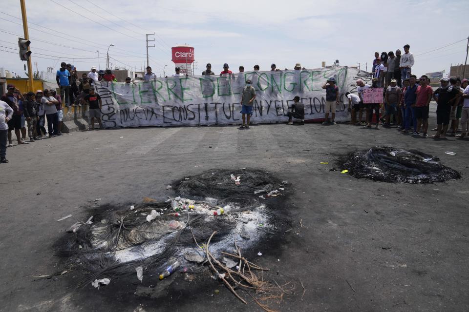 Supporters of ousted Peruvian President Pedro Castillo block the Pan-American South Highway with a sign that reads in Spanish "Close Congress. New Constitution and Elections" in Ica, Peru, Tuesday, Dec. 13, 2022. Castillo said Tuesday he is being "unjustly and arbitrarily detained" and thanked his supporters for their "effort and fight" since he was taken into custody last week. (AP Photo/Martin Mejia)