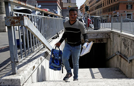 Christian Okoro of Nigeria holds his stuffs after sweeping a street in downtown Rome, Italy, May 18, 2017. Picture taken May 18, 2017. REUTERS/Max Rossi