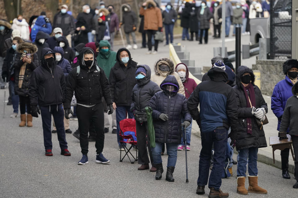 People wait in line for the COVID-19 vaccine in Paterson, N.J., Thursday, Jan. 21, 2021. The first people arrived around 2:30 a.m. for the chance to be vaccinated at one of the few sites that does not require an appointment. With millions of Americans waiting for their chance to get the coronavirus vaccine, a fortunate few are getting bumped to the front of the line as clinics scramble to get rid of extra, perishable doses at the end of the day. (AP Photo/Seth Wenig)